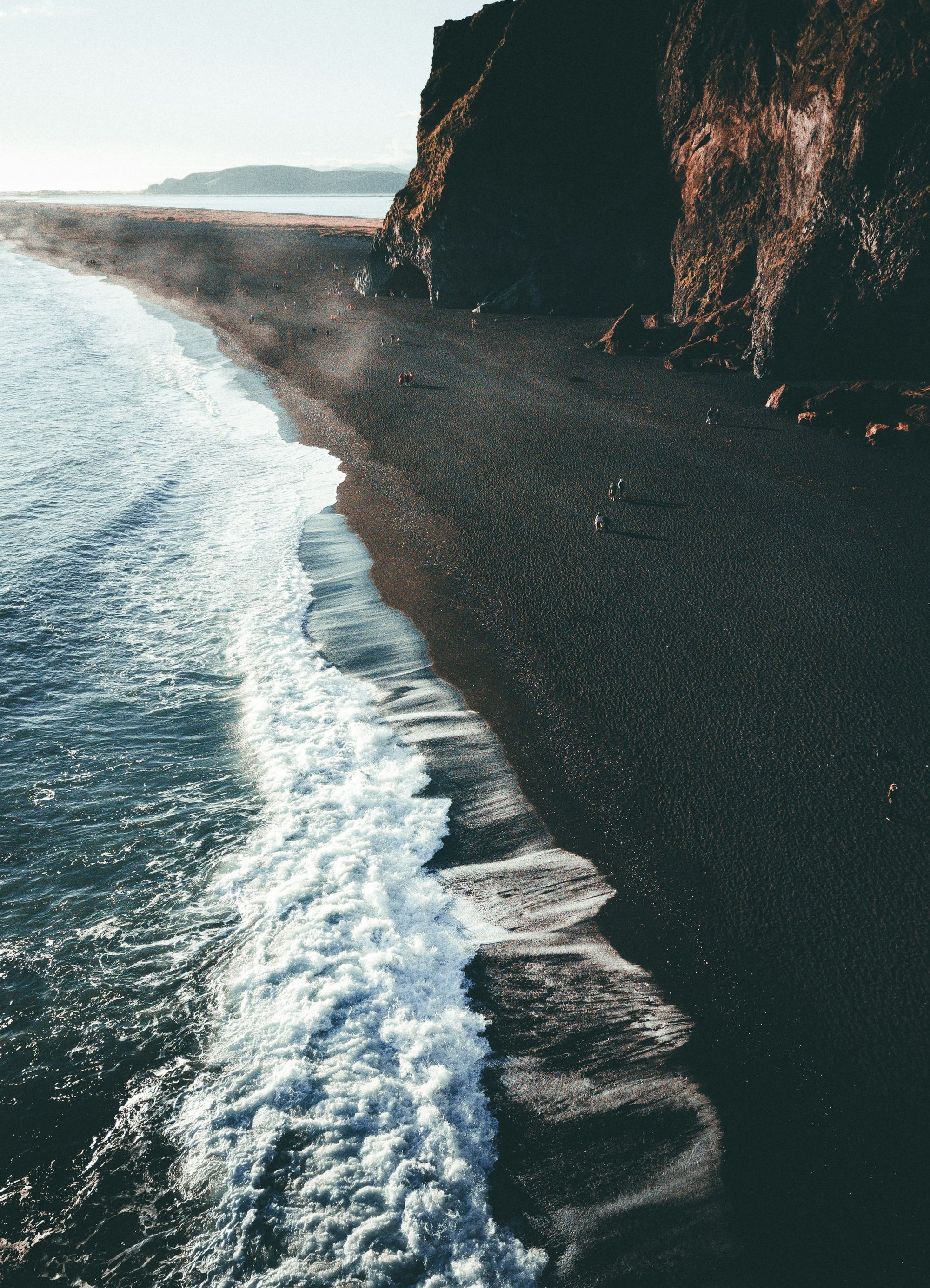 A black-sand shore seen from above
